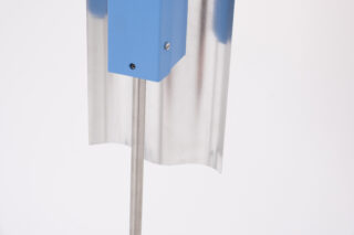 Eine vertikale Metallstange trägt einen blauen, rechteckigen Kasten vor einem gewellten, silbernen Metallblech vor einem schlichten weißen Hintergrund.