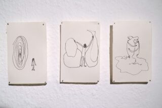 Drei weiße Papierbögen mit abstrakten schwarzen Strichzeichnungen sind in einer Reihe an eine weiße, strukturierte Wand gepinnt.