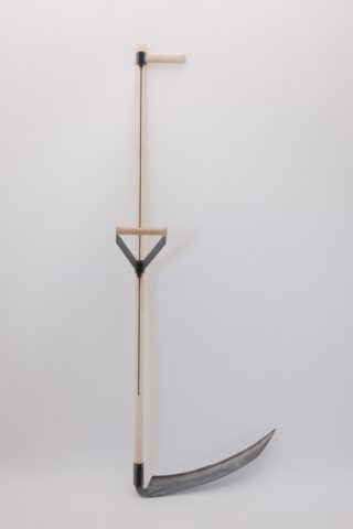 Eine Sense mit einem langen Holzgriff, einem senkrechten Handgriff und einer gebogenen Metallklinge, fotografiert vor einem schlichten weißen Hintergrund.