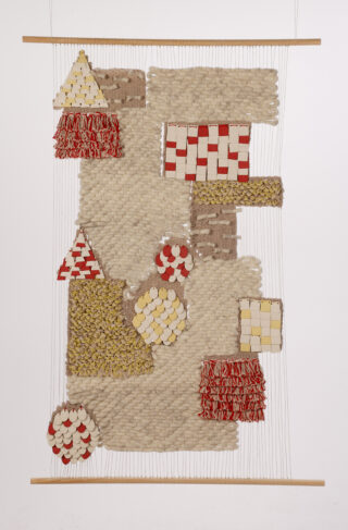 Ein Wandbehang mit strukturierten, gewebten und geschichteten geometrischen Formen in Rot, Gelb, Weiß und Beige auf einem vertikalen Webstuhl mit Holzstäben am oberen und unteren Ende.