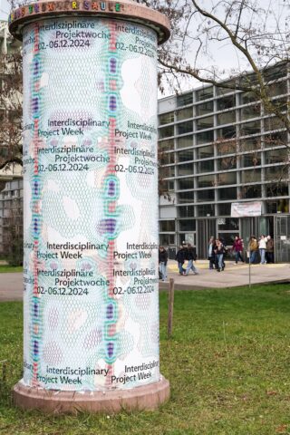 Eine zylindrische Säule im Freien, die mit Plakaten bedeckt ist, die die 