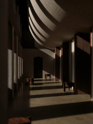 Das Sonnenlicht fällt durch hohe Fenster auf Bänke und einen gefliesten Boden in einem Flur mit hohen, geschwungenen Decken und einer zentralen Bogentür.