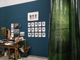 Ein Zimmer mit einer blauen Wand und einem grünen Vorhang.