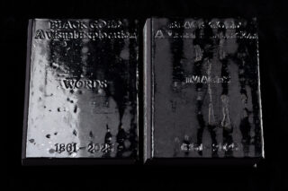 Zwei schwarze Bücher mit glänzendem Einband mit dem Titel 