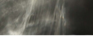 Unscharfes, abstraktes Bild mit grauen und schwarzen Tönen und einem weißen Streifen am unteren Rand.