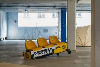 Drei gelbe Plastiksitze auf Rädern mit der Aufschrift ACEDIA 3X
