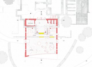 Architektonischer Grundriss, der einen Gebäudebereich mit beschrifteten Räumen, Möbeln, Zugangswegen und der Außenumgebung zeigt; Räume und Wände sind rot und gelb hervorgehoben.