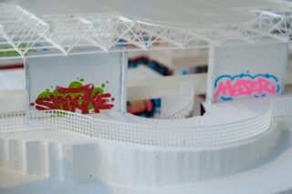 Ein weißes Architekturmodell weist geschwungene Rampen, Maschendrahtzäune und simulierte Graffiti an den Innenwänden in Rot-Grün- und Rosa-Blau-Farbtönen auf.