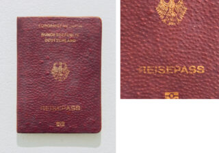 Ein kastanienbrauner deutscher Reisepass mit goldener Beschriftung und Emblem auf dem Einband, darunter die Aufschrift „Reisepass“ und das Symbol für einen biometrischen Reisepass.