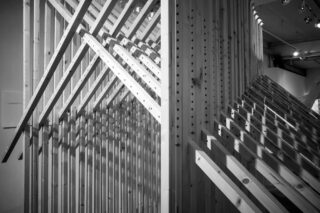 Eine architektonische Installation aus einem Holzgitterrahmen mit diagonalen Verstrebungen.