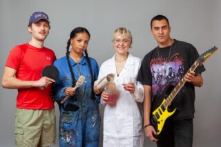 Vier junge Erwachsene posierten gemeinsam und hielten dabei einen Tischtennisschläger, einen Pinsel, Laborgeräte und eine E-Gitarre in den Händen.